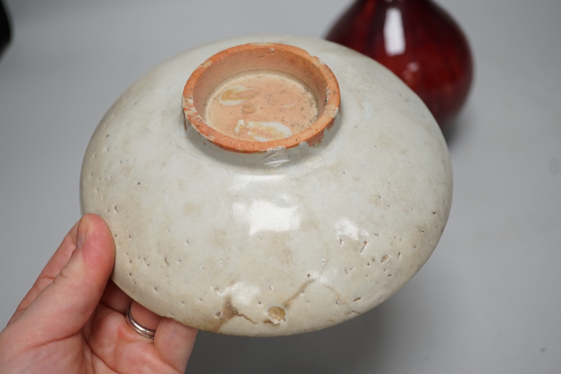 A Chinese sang de boeuf glazed bottle neck vase, together with a Chinese blue and white tea bowl, and a Chinese dish, tallest 23cm